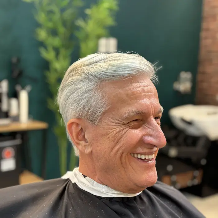 Cliente de cabelo branco sorrindo na cadeira