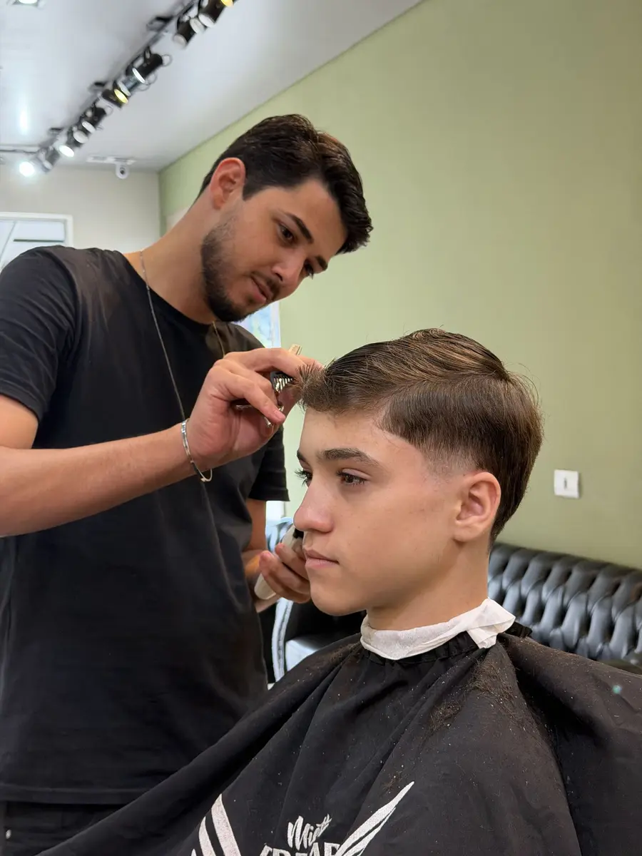 Barbeiro finalizando o corte de um cliente